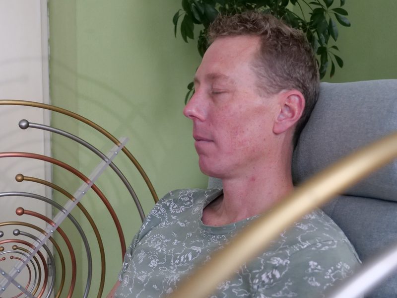 Cliënt met gesloten ogen tijdens een MWO-sessie tussen de antennes
