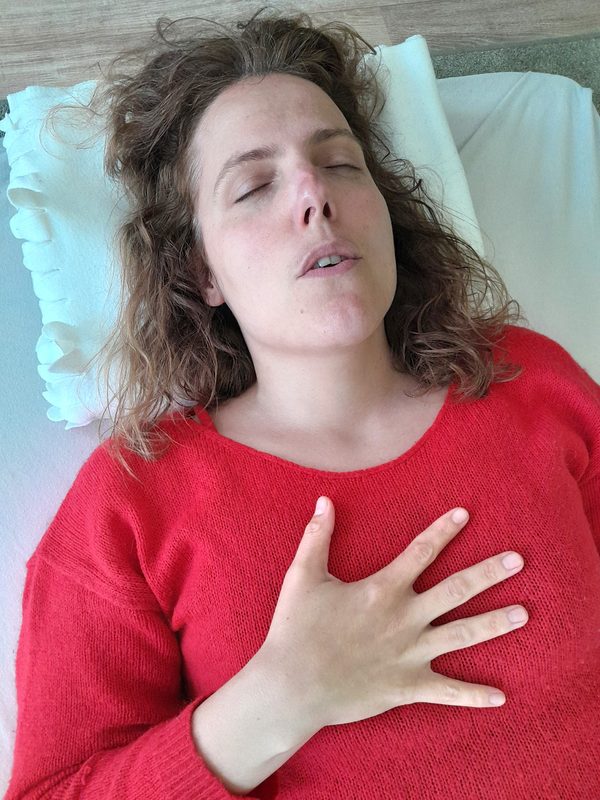 Cliënt met geopende adem, handen op borst en buik tijdens een ademsessie